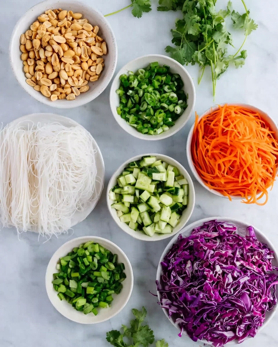 The image shows six white bowls and plates arranged on a white marbled surface. One bowl contains light brown peanuts, another has bright green chopped spring onions, and a plate holds thin slices of orange carrots. There is a block of white rice noodles placed flat on the surface, while a bowl holds chopped green cucumbers, and another bowl is filled with shredded purple cabbage with white streaks. Sprigs of green cilantro lie next to the bowls. The overall presentation is colorful with fresh and vibrant vegetables and nuts, all placed neatly. Photo taken with an iphone --ar 4:5 --v 7