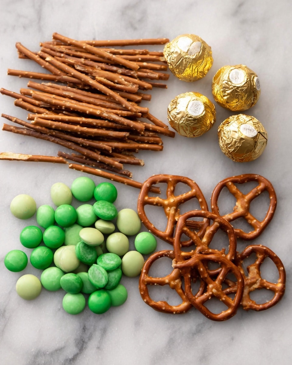 The image shows three groups of snacks arranged on a white marbled surface. On the left side, there is a pile of thin, long, light brown pretzel sticks scattered in a loose pile. In the middle, there are two rows of round candy pieces in different shades of green, with a glossy and smooth surface. At the top center, there are three wrapped chocolates with golden foil, and on the right side, there is a small cluster of larger pretzels with a light brown color and a rough, slightly salty texture. Photo taken with an iphone --ar 4:5 --v 7