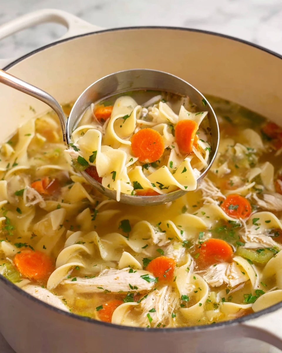 The image shows a white pot filled with clear chicken soup with wide egg noodles in a pale yellow color, soft orange carrot slices, small pieces of light beige chicken, and bits of green herbs and celery floating throughout. A silver ladle is lifted above the soup full of the same ingredients, highlighting the light textures and colors of the noodles, carrots, and chicken in the golden broth. The pot rests on a white marbled surface that adds a clean look to the scene. photo taken with an iphone --ar 4:5 --v 7