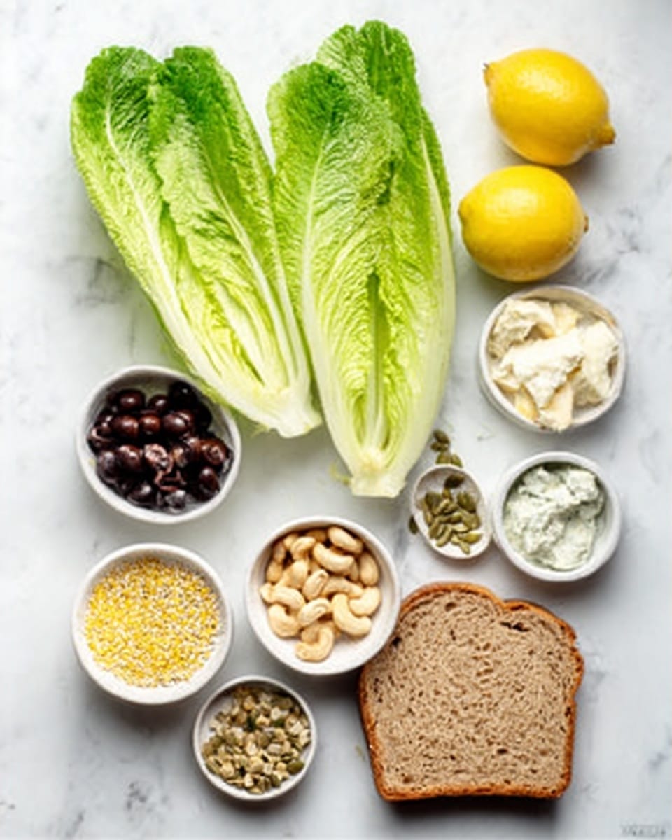 The image shows an arrangement of fresh food ingredients on a white marbled surface. There are two fresh green Romaine lettuce leaves placed side by side near the center. Around them, small white bowls hold different ingredients: one with black olives, another with chopped cashews, one with yellow grains, one with seeds, and one with a creamy white substance. Two halved lemons are also present near the top right. At the bottom, a single slice of brown bread lies flat, showing its texture. The overall layout is neat and colorful with natural tones, captured clearly. Photo taken with an iphone --ar 4:5 --v 7