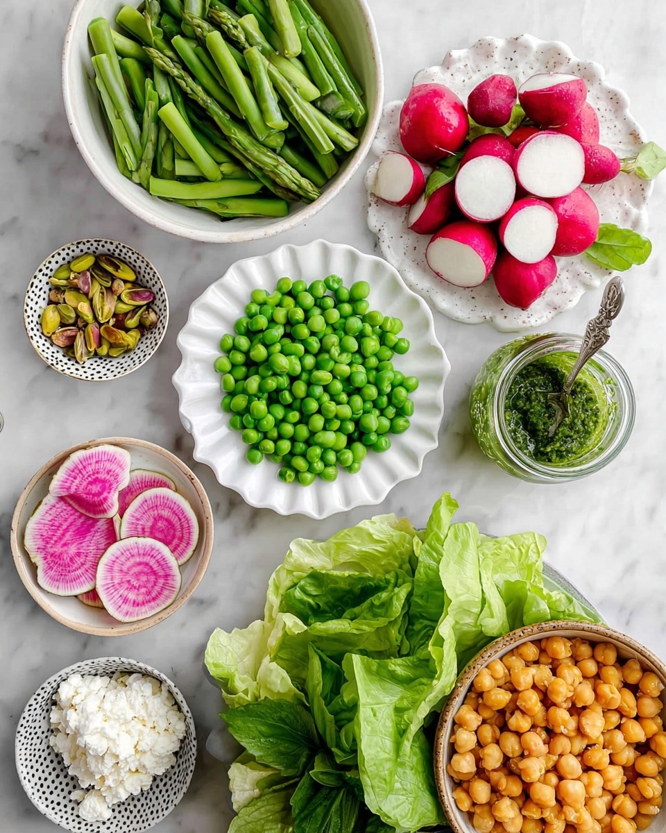 The image shows several bowls and plates with fresh, colorful ingredients placed on a white marbled surface. There is a white bowl in the top center filled with bright green asparagus cut into segments. Below that, a white scalloped plate holds round, vivid green peas. To the right, a clear jar with a spoon contains a green herb sauce. Nearby, a small bowl holds sliced red radishes with white centers, next to whole and halved radishes with red skin. At the bottom left, a small bowl contains thinly sliced rounds of watermelon radish with pink centers and white edges. Below that, a spotted bowl is filled with white crumbly cheese. Fresh green leafy lettuce and basil sit in the lower center. On the right, a large white bowl holds golden roasted chickpeas, and a small bowl with chopped pistachio nuts is to its left. The bright colors and fresh look stand out vividly. photo taken with an iphone --ar 4:5 --v 7