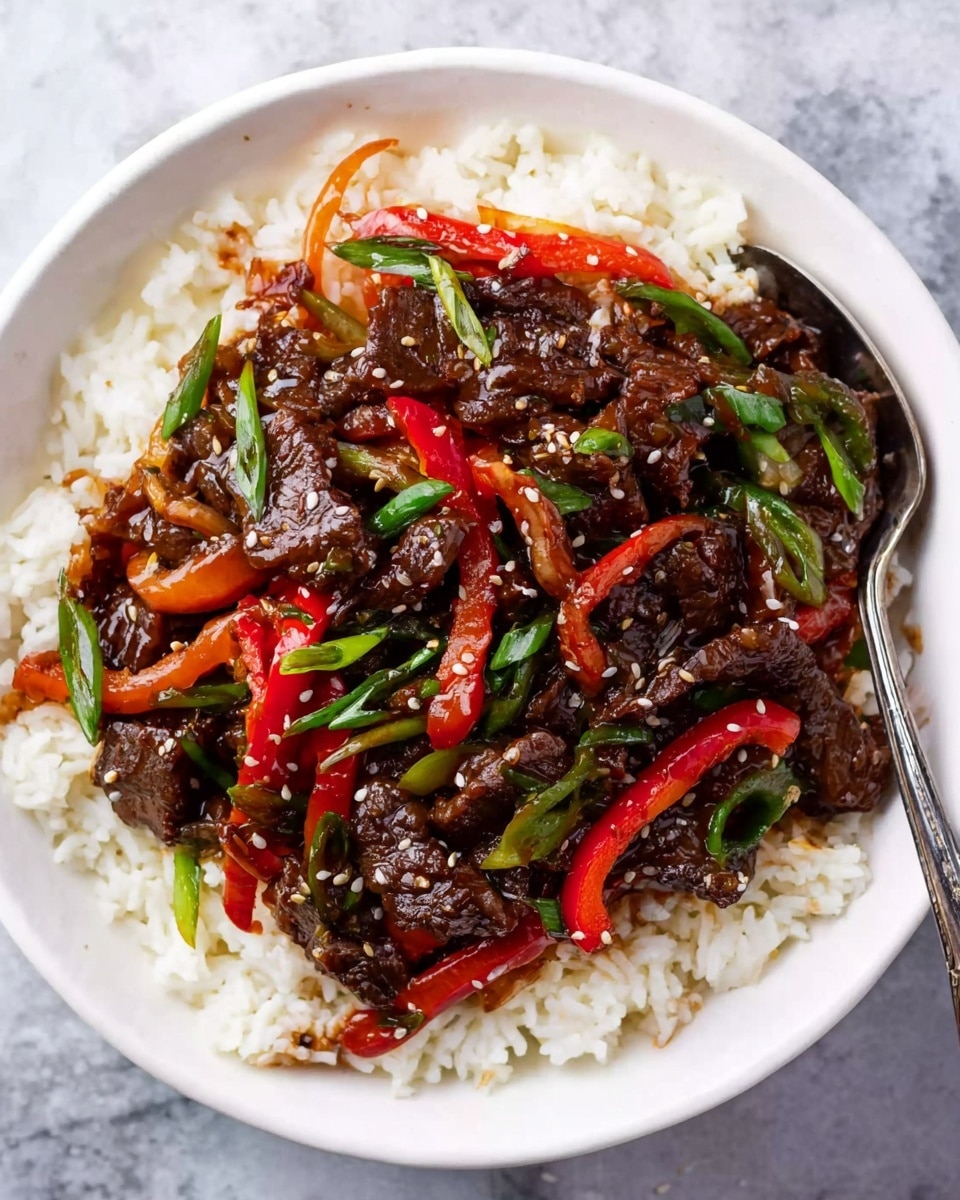 A white bowl filled with a bed of white rice, topped with dark brown stir-fried beef pieces mixed with thin slices of red bell pepper and green onions. The beef and vegetables are shiny with a thick sauce that coats them evenly, and small sesame seeds are sprinkled on top. A silver spoon is placed inside the bowl on the right side. The bowl rests on a white marbled surface. Photo taken with an iphone --ar 4:5 --v 7