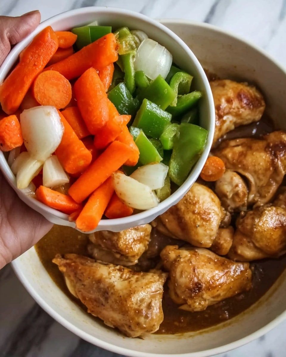 A woman's hand is holding a white bowl filled with raw vegetables above a pan of cooked chicken pieces in brown sauce. The bowl has three types of vegetables layered together: bright orange carrot slices, fresh green bell pepper chunks, and white onion pieces all mixed evenly. Below, the pan contains seven cooked chicken pieces, each golden brown with a slightly glossy texture from the sauce, which is spread thinly covering the meat. The background surface is a white marbled texture. photo taken with an iphone --ar 4:5 --v 7