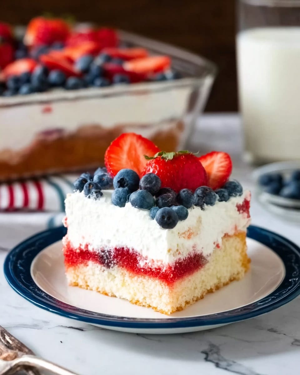 A rectangular dessert in a metal pan is styled like the American flag with three sets of diagonal red strawberry slices alternating with three rows of white whipped cream rosettes, while the top left corner is filled with a grid of whole blueberries on a white cream base. Around the pan, there is a bowl of whole strawberries, a folded white cloth with blue stars and a red wavy trim, a white plate with two gold forks on it, and scattered blueberries and small red, white, and blue star-shaped confetti, all set on a white marbled surface. photo taken with an iphone --ar 4:5 --v 7