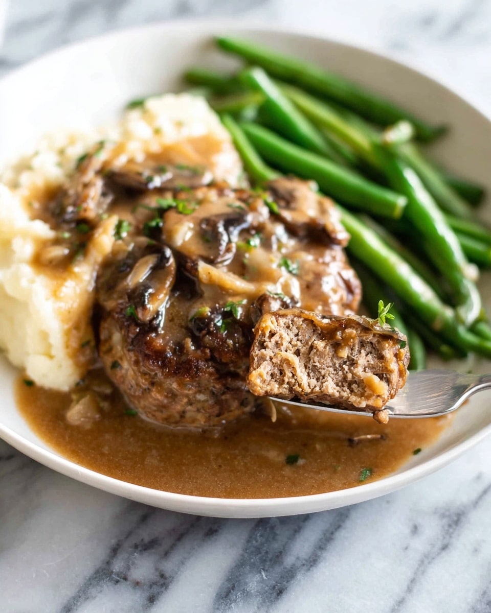 The image shows a close-up of two browned meat patties in a white pot filled with a brown mushroom sauce. Each patty is topped with soft, sliced mushrooms and translucent cooked onion pieces. Small bits of fresh green herbs are sprinkled over the sauce and patties, adding a touch of color. The texture of the patties looks juicy and tender, with a rich, glossy sauce coating them. A silver spoon lifts one patty out of the pot, showing the glossy mushroom sauce and bits of herbs clearly on top and around the meat, all set against a white marbled surface. photo taken with an iphone --ar 4:5 --v 7