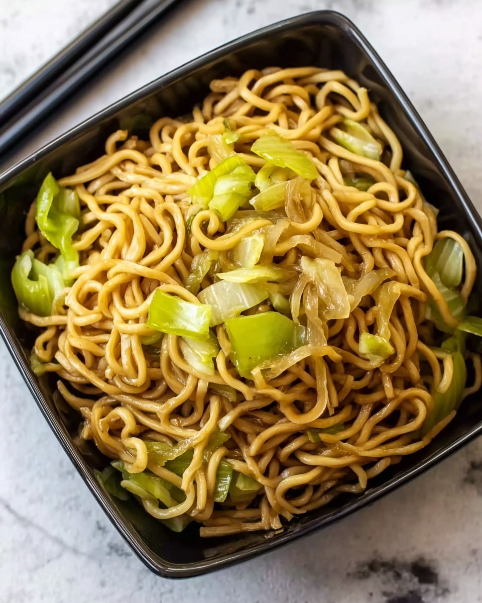 The image shows a single layer of cooked yellow noodles mixed with sliced green celery and light brown onion pieces, all inside a square black bowl. The noodles have a slightly shiny texture, and the vegetables are spread evenly on top and within the noodles. The bowl is placed on a white marbled surface, and a pair of black chopsticks rests near the bowl. photo taken with an iphone --ar 4:5 --v 7