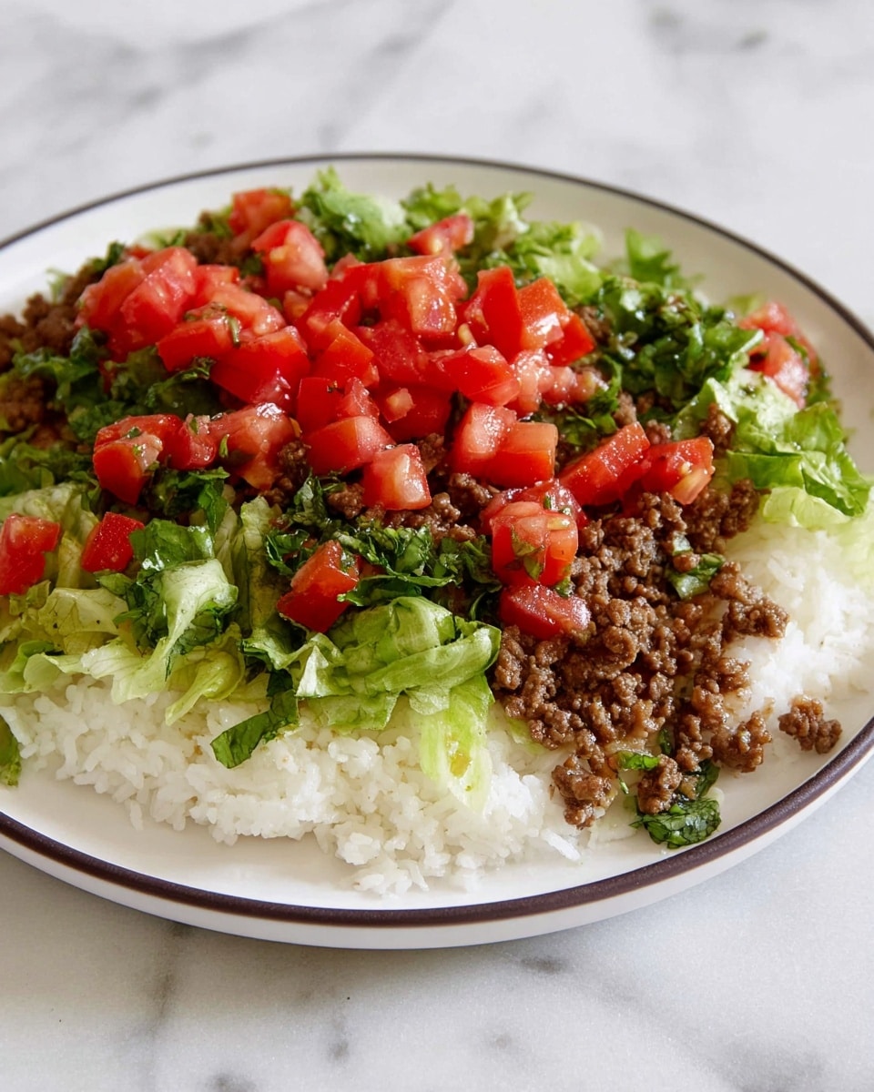 A white plate with a thin dark edge holds a layered dish. The bottom layer is white cooked rice with a fluffy texture, mostly on the left side. On top and slightly to the right, there is a layer of finely chopped green lettuce, fresh and leafy. Over the lettuce and rice is a layer of cooked ground meat, brown and crumbly. Bright red chunks of fresh tomatoes are scattered on top, adding a fresh, juicy look. The plate is set on a white marbled surface. photo taken with an iphone --ar 4:5 --v 7
