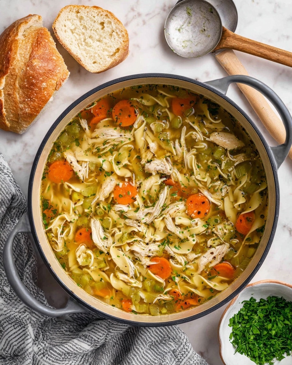 A large pot filled with chicken noodle soup sits on a white marbled surface. Inside the pot, the soup has several layers: an orange layer of sliced carrots, a pale yellow layer of wide egg noodles, a green layer of celery chunks and herbs, and shredded white chicken pieces all floating in a clear broth with specks of black pepper and parsley sprinkled over the top. Around the pot, there are a few slices of crusty bread with a light golden crust, a small white bowl filled with fresh green parsley, a wooden spoon resting on a gray and white striped cloth, and a metal ladle on the surface. The scene is simple and homey. photo taken with an iphone --ar 4:5 --v 7