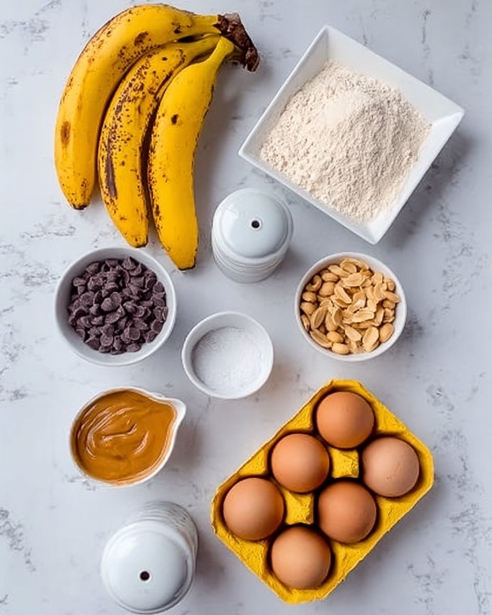 The image shows key ingredients arranged on a white marbled surface. There are three yellow bananas with some brown spots on their skin placed near the top left. A white square dish holds a heap of light beige flour on the top right. Below the bananas, a small white round bowl contains dark purple chocolate chips. Next to it, there is a white round bowl filled with light brown peanuts. In the center, a white cup with a small spout holds smooth golden peanut butter. Nearby, a white round bowl has fine white salt, while a white pepper grinder is positioned close by. An open yellow egg carton holds two brown eggs towards the bottom right. The photo taken with an iphone --ar 4:5 --v 7