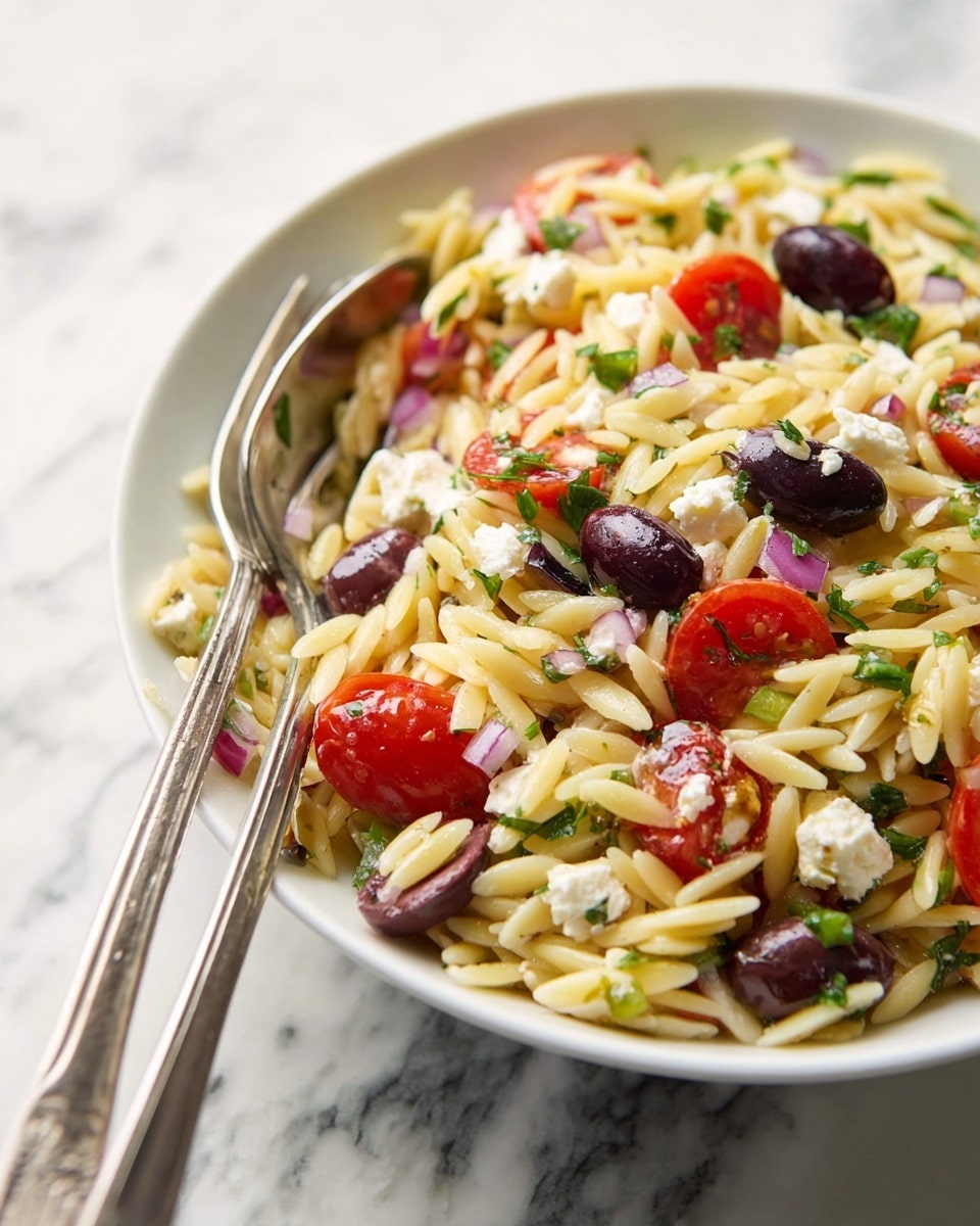 A white bowl filled with a colorful orzo salad sits on a white marbled surface. The salad has three main layers: the bottom layer is small, light yellow orzo pasta with a slightly glossy texture; mixed throughout are bright red halved cherry tomatoes and dark purple and black whole olives, giving bursts of color; scattered among these are small chunks of white cheese and diced green bell peppers adding a crunchy texture. The salad looks lightly coated with green herbs and a dressing that adds a slight shine. photo taken with an iphone --ar 4:5 --v 7