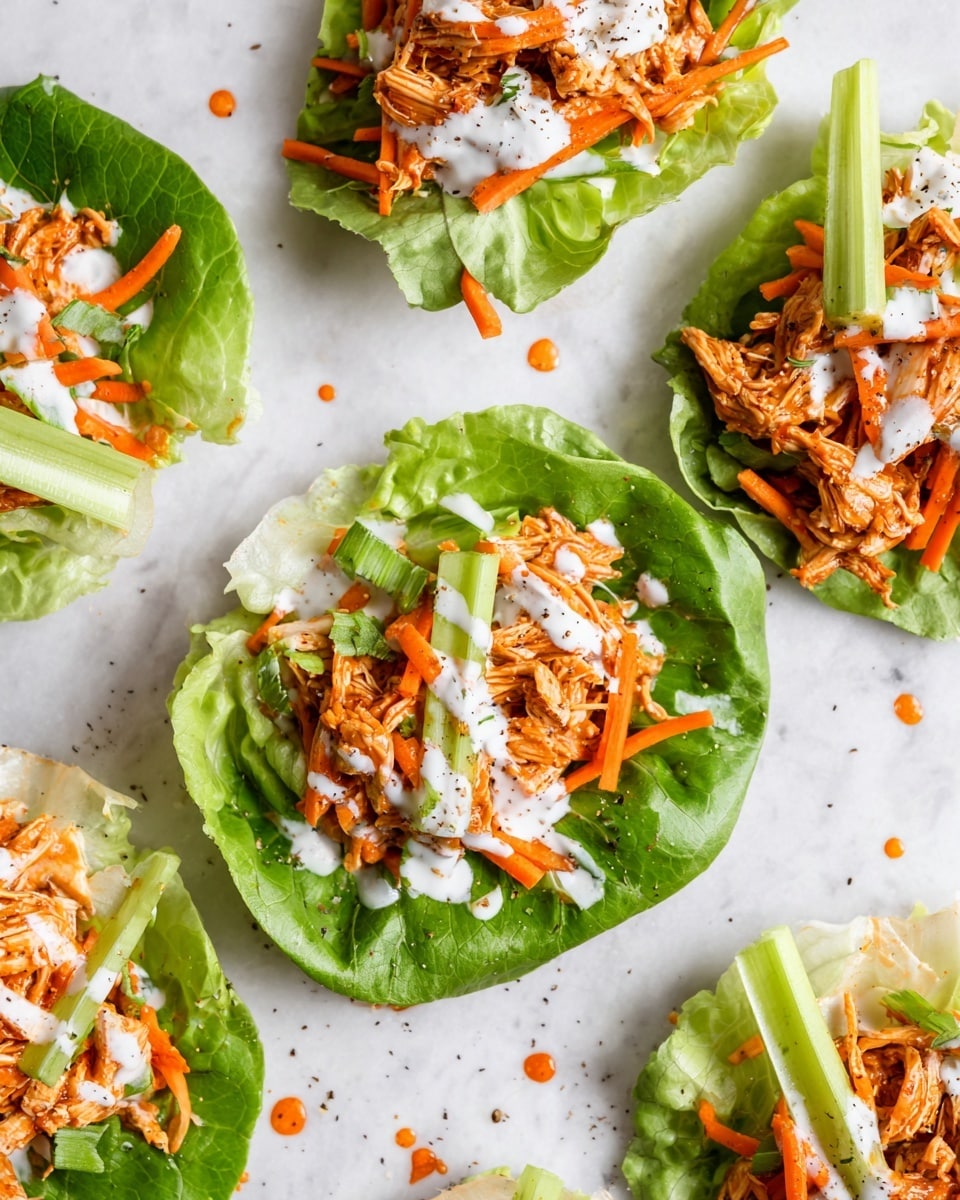 The image shows several pieces of green lettuce leaves laid flat on a white marbled surface, each topped with a mix of shredded orange chicken, thin carrot sticks, and thin celery sticks. The chicken and vegetables are drizzled with white creamy dressing and orange sauce, with small drops of sauce visible on the surface around the lettuce wraps. The textures show a fresh, crisp lettuce base, a tender shredded chicken layer, and fresh crunchy vegetables on top. The layers are arranged neatly with visible seasoning of black pepper on the sauce. photo taken with an iphone --ar 4:5 --v 7