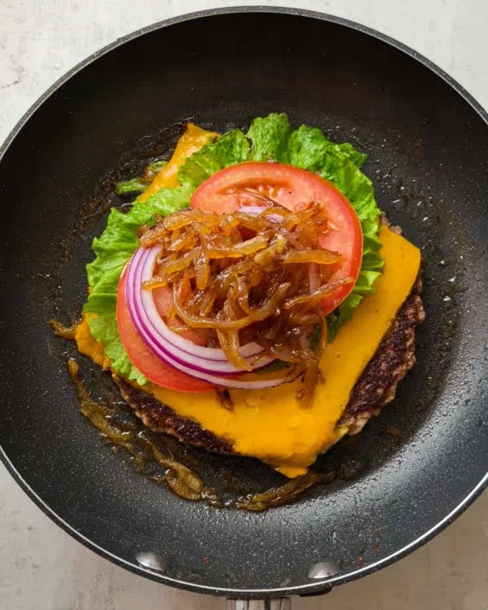 A cooked burger patty sits in the middle of a frying pan on a white marbled surface. On top of the patty, there is a layer of melted yellow cheese followed by a layer of fresh green lettuce leaves. Above the lettuce, several thin tomato slices and thin purple onion rings are stacked, all crowned with a pile of caramelized onions that have a golden-brown color. The pan's black non-stick surface frames the vibrant layers of the burger ingredients. Photo taken with an iphone --ar 4:5 --v 7