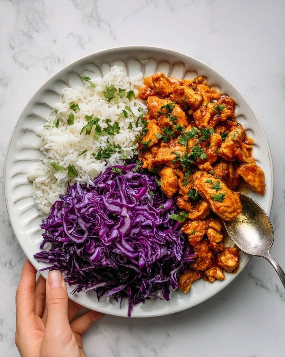 The image shows a white plate with three main parts: on the left side, there is a layer of white rice with a soft texture; next to it on the right is a pile of bright purple shredded cabbage that looks fresh and crunchy; above both is a layer of golden brown pieces of cooked chicken with a light sauce, garnished with small green herbs. Around the plate, there are other white dishes, one with more shredded purple cabbage, one with green chopped herbs, and a small white bowl of orange sauce. Two silver forks rest on a white napkin on a white marbled surface. Photo taken with an iphone --ar 4:5 --v 7